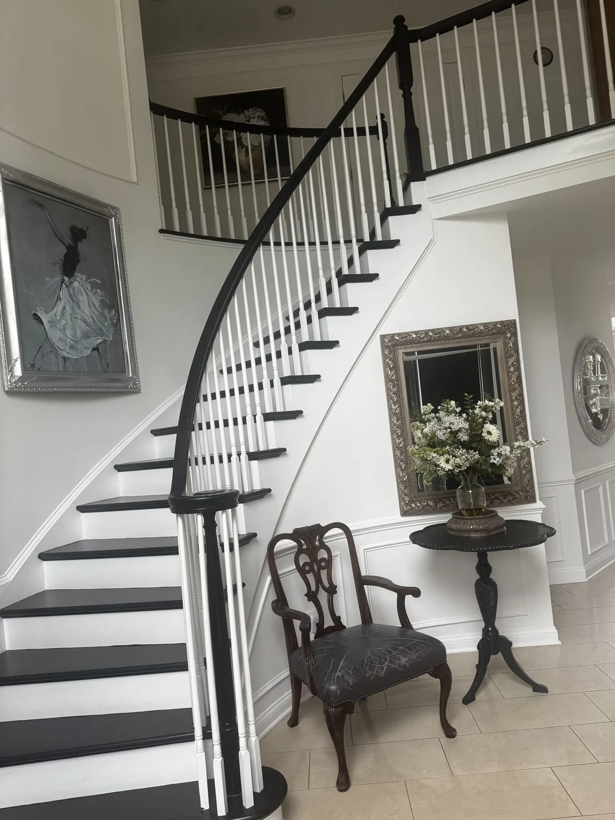 Staircase with a carved chair and floral arrangement